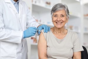 Un medico mentre inietta il vaccino ad una persona anziana