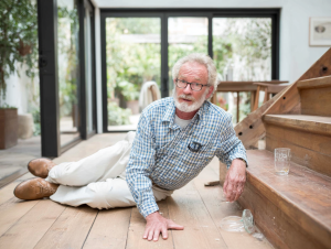 Uomo di mezza età è ai piedi di una scala, perché appena caduto